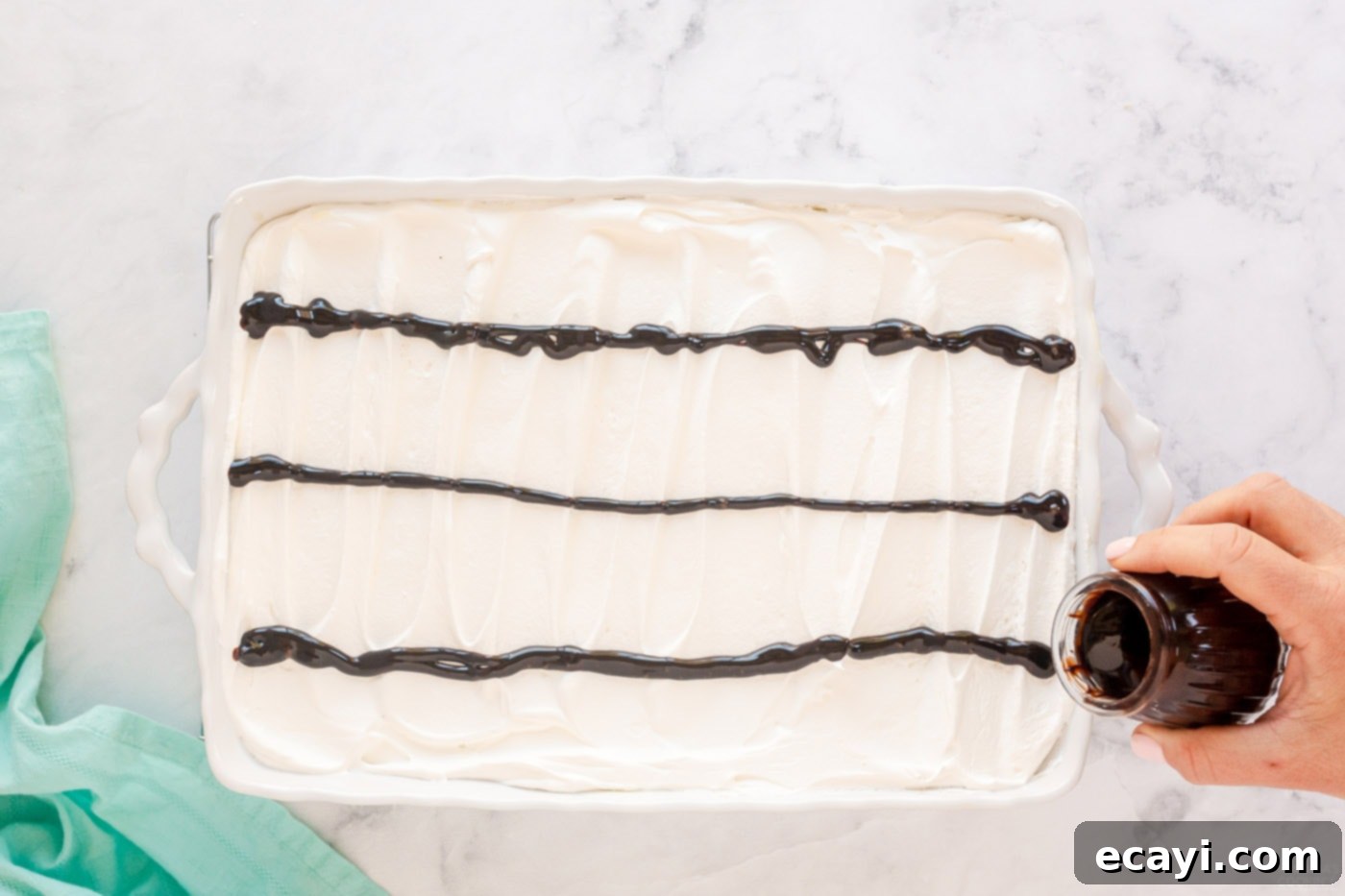 Ultimate Chocolate Eclair Puff Cake 10 pouring lines of chocolate on top of cake