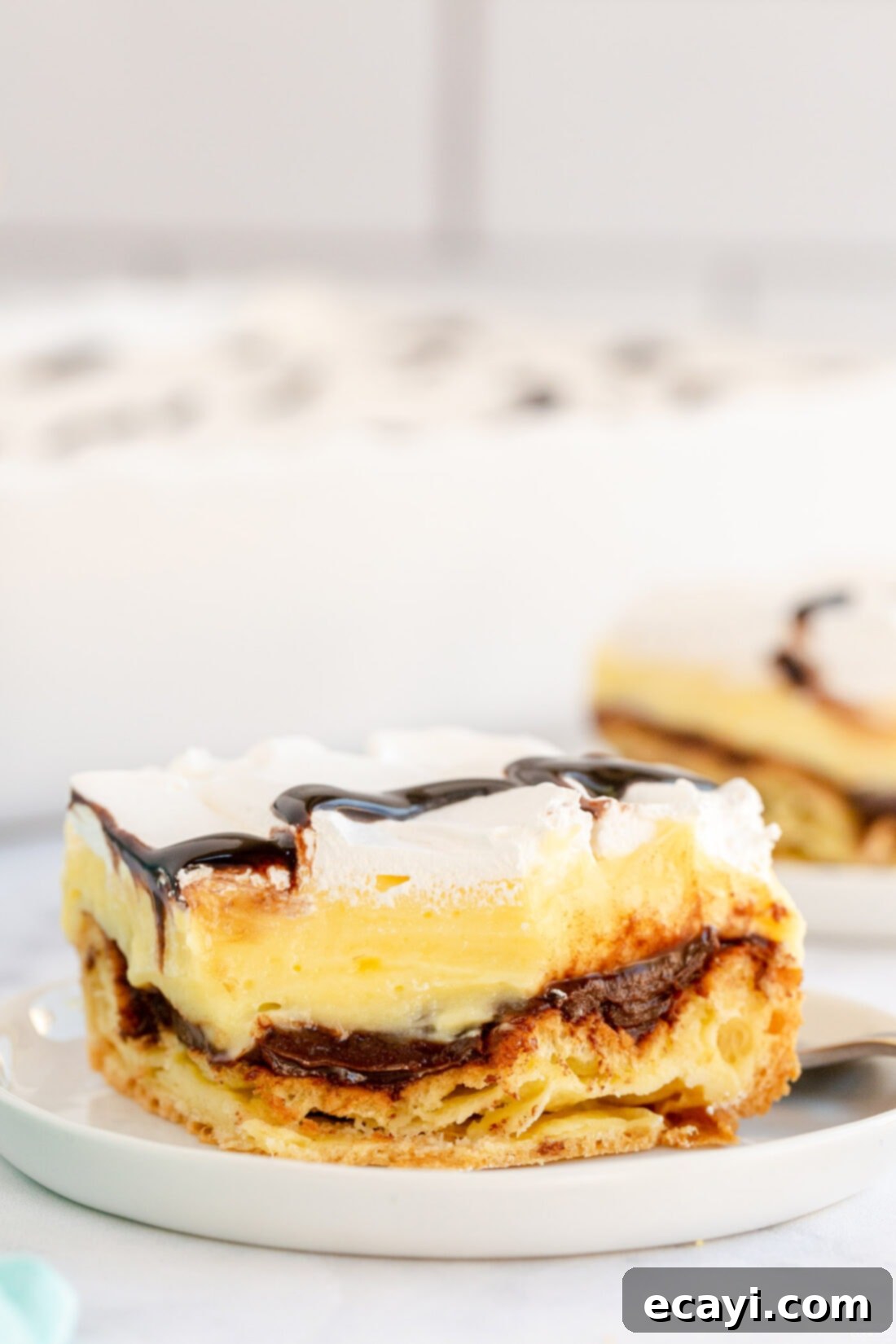 Ultimate Chocolate Eclair Puff Cake 3 slice of Cream Puff Chocolate Eclair Cake on plate