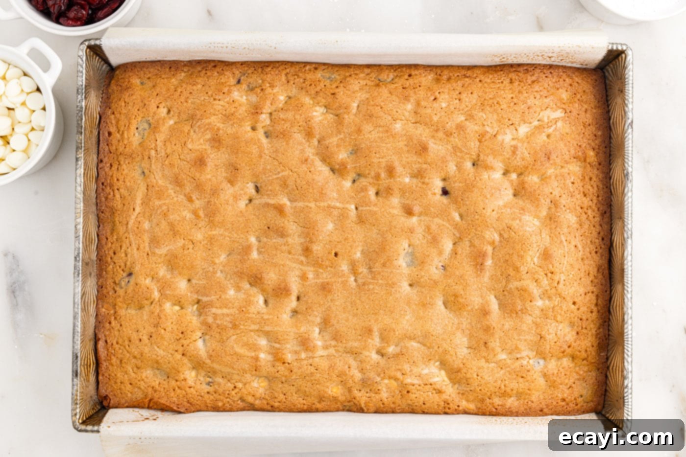 Dreamy Cranberry Squares 14 Baked white chocolate cranberry blondies lifted from the pan with parchment paper