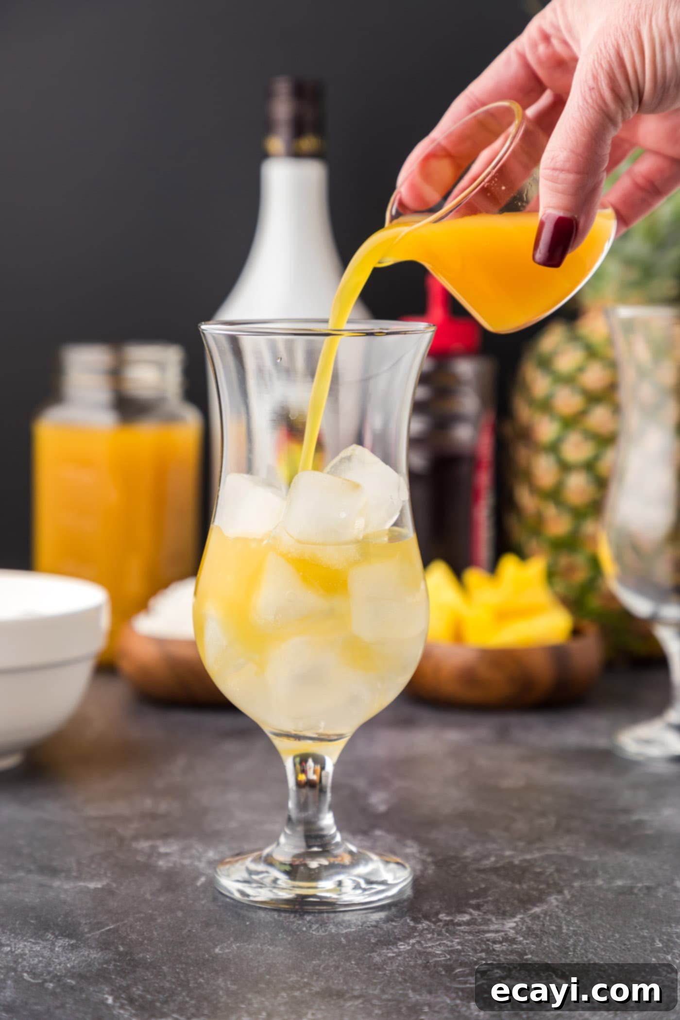 Malibu's Golden Hour 7 pouring pineapple juice into glass of Malibu rum and ice