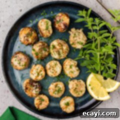 Succulent Grilled Scallops 12 Plate of Grilled Scallops with herbs and lemon slices on the side