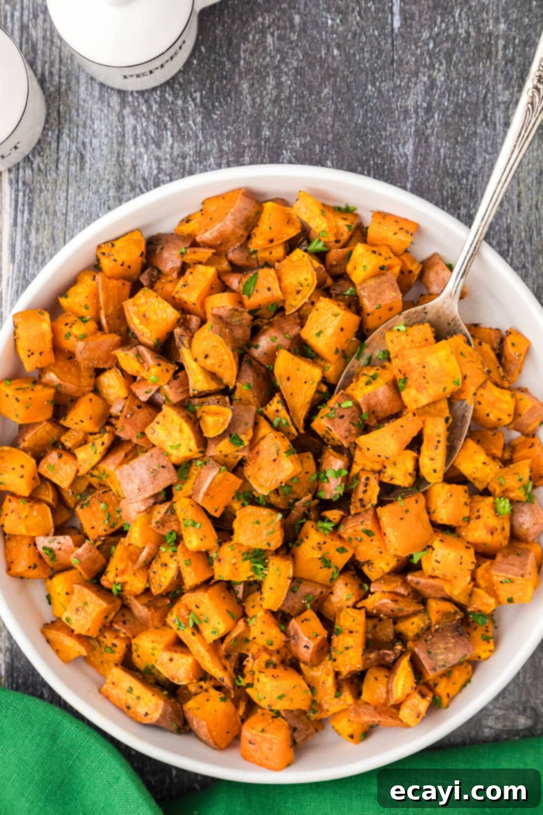 The Ultimate Roasted Sweet Potatoes 10 Bowl of Roasted Sweet Potatoes with a spoon in it