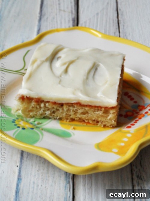 Luscious Banana Bars with Velvety Vanilla Frosting 2 A close up photo of a banana bar with vanilla cream cheese frosting on a plate, ready to be enjoyed.