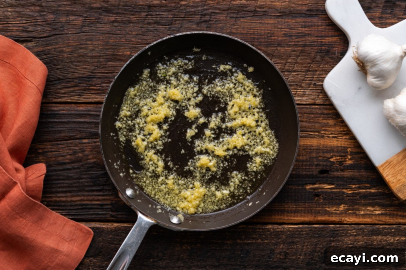 Ultimate Garlic Parmesan Wing Sauce 6 oil and minced garlic cooking in a skillet