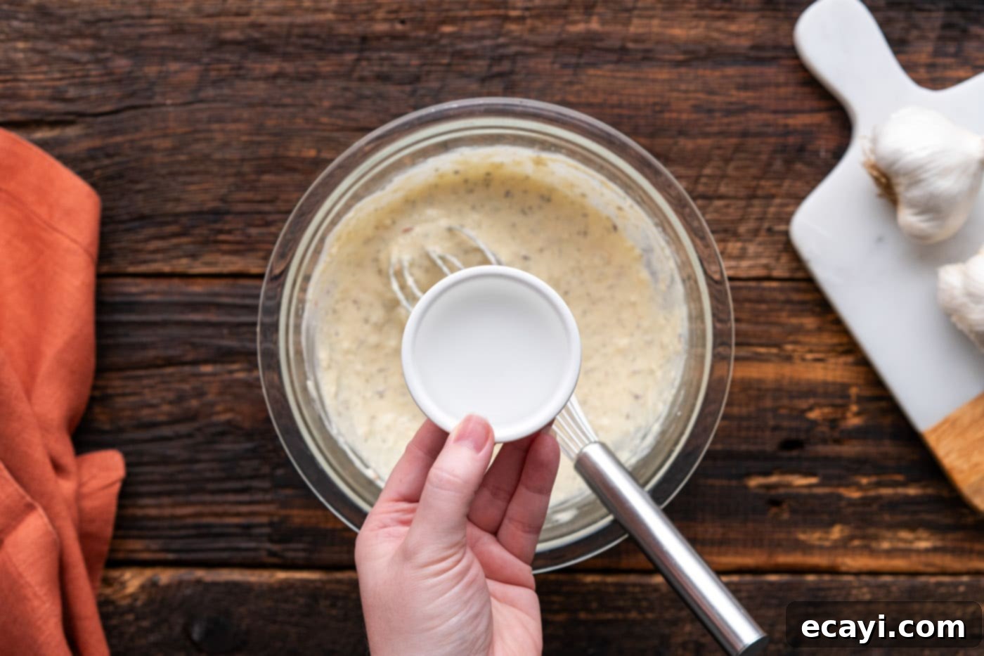 Ultimate Garlic Parmesan Wing Sauce 9 adding water to bowl of wing sauce