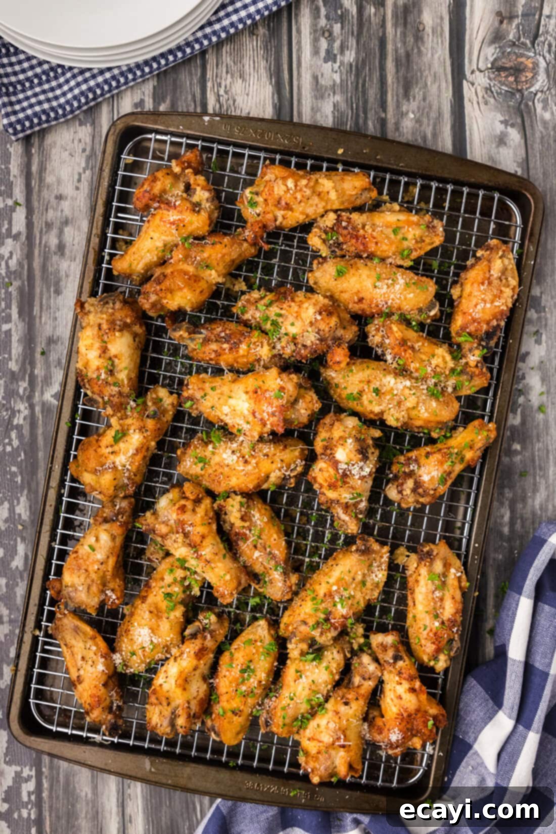 Crispy Garlic Parmesan Wings 2 Crispy fried garlic parmesan wings drizzled with sauce on a wire rack