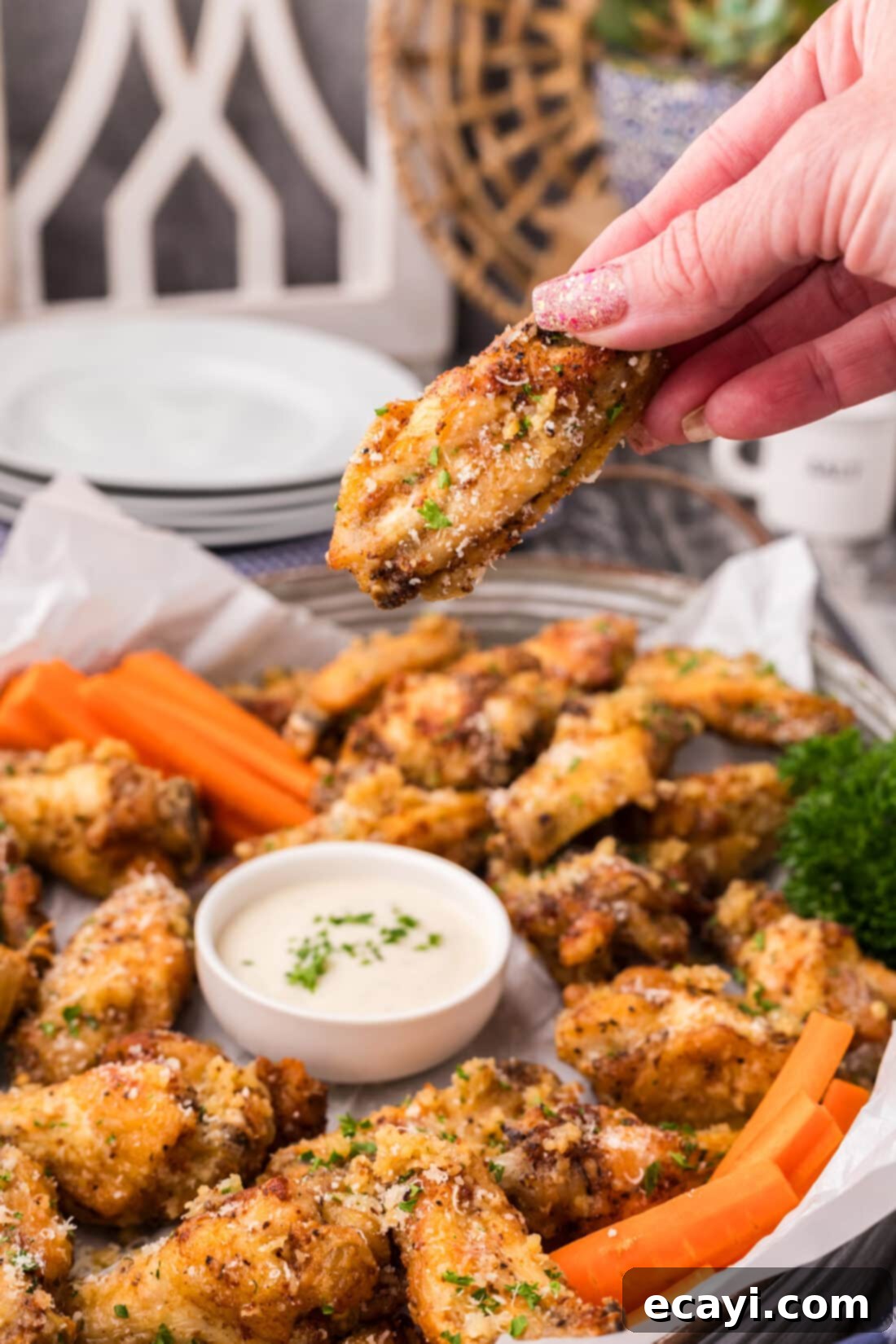 Crispy Garlic Parmesan Wings 17 Hand holding a single crispy garlic parmesan chicken wing