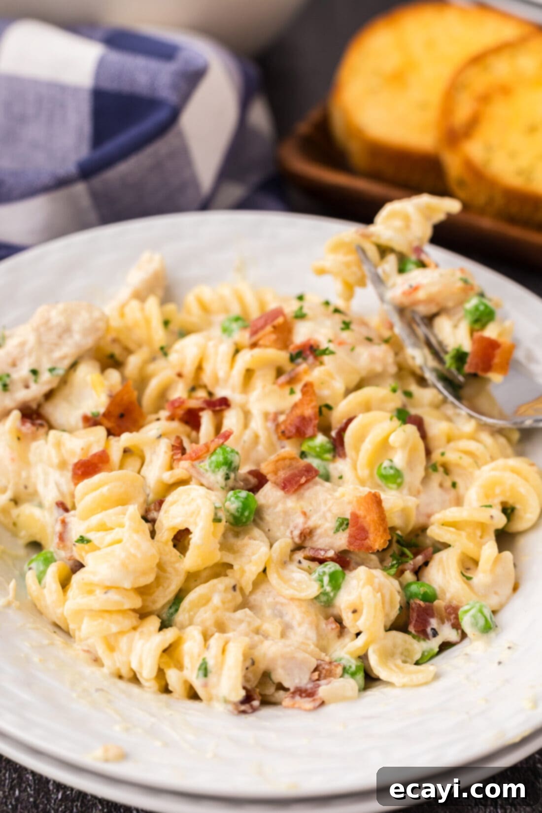 Surf and Turf Carbonara 2 Close up photo of a bowl of Chicken and Shrimp Carbonara, showcasing the creamy sauce, tender pasta, chicken, shrimp, and green peas.