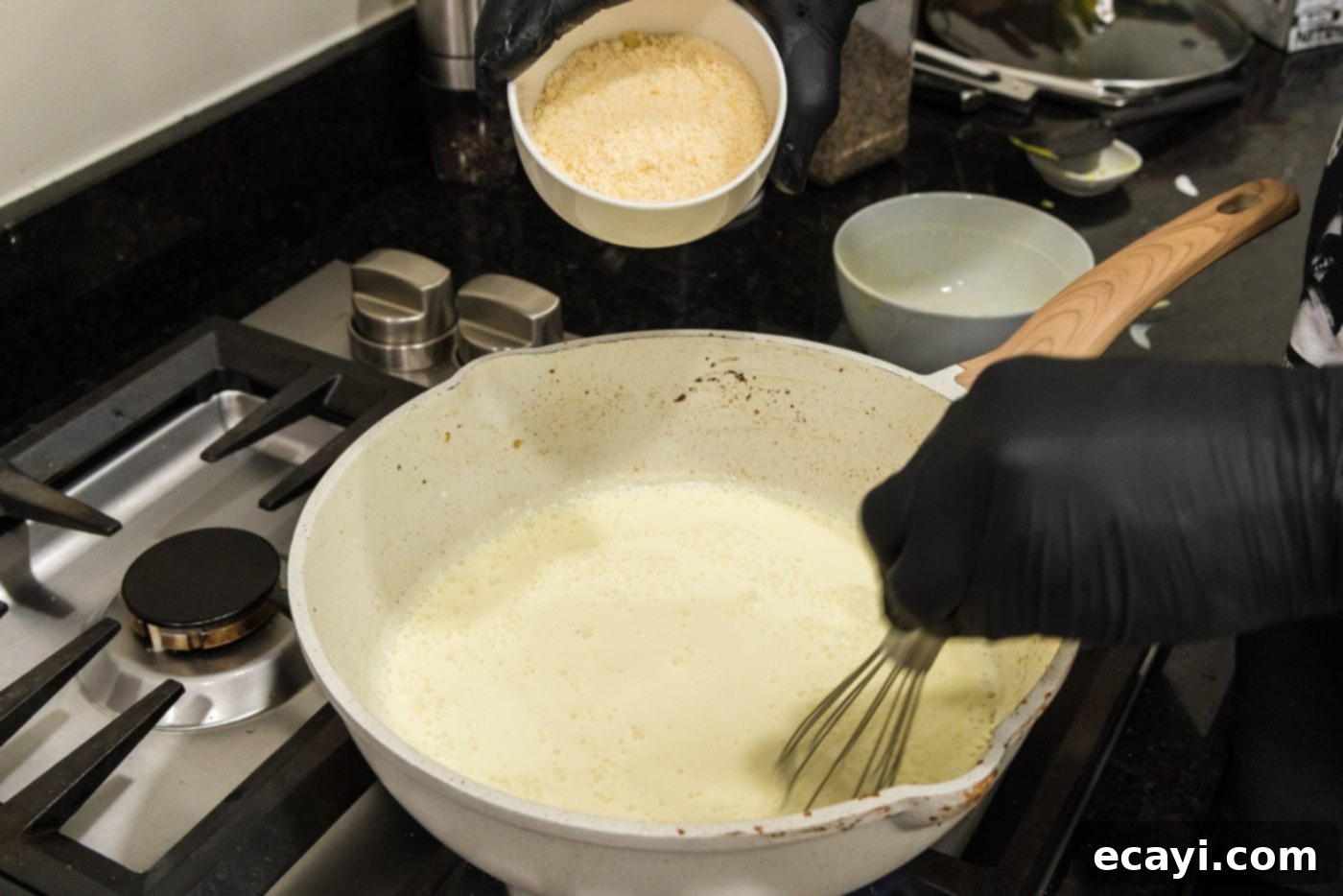 Surf and Turf Carbonara 13 adding parmesan cheese to heavy cream and egg mixture in a skillet