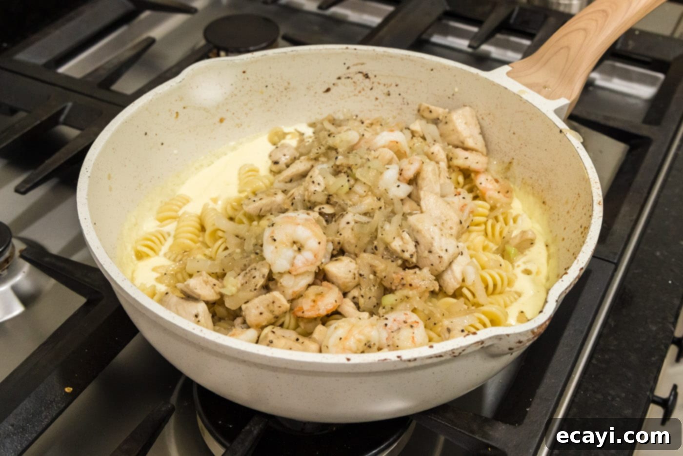 Surf and Turf Carbonara 14 adding chicken and shrimp mixture to skillet with pasta and carbonara sauce