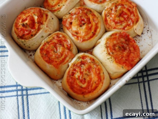 Pizza Pinwheels 11 Freshly baked pizza roll ups in a baking pan, showing the golden crust and melted cheese.