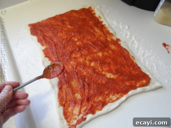 Pizza Pinwheels 7 Refrigerated pizza dough rolled out into a rectangle on a floured surface.