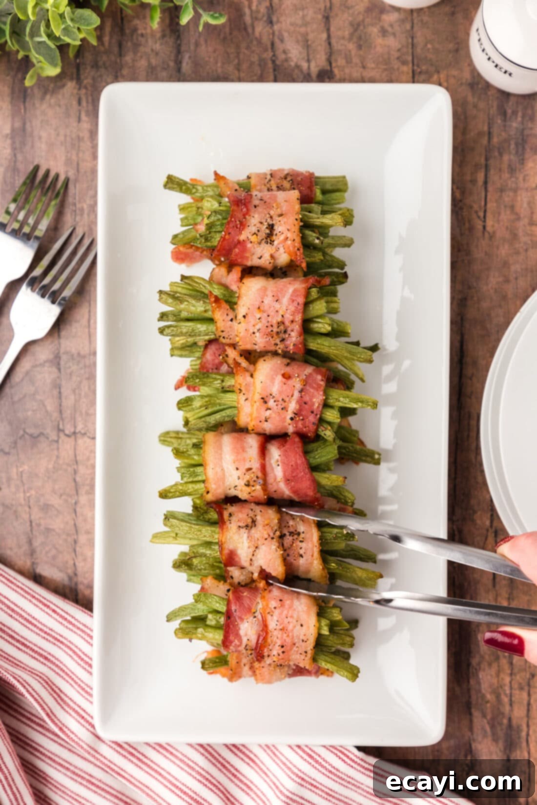 Bacon Green Bean Bundles 3 Bacon Wrapped Green Bean bundles stacked on a white serving platter