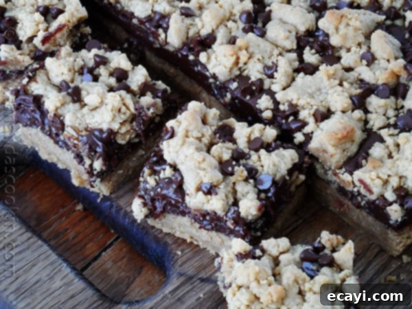Peanut Butter Chocolate Bliss Bars 4 An overhead photo of peanut butter chocolate layer bars resting on a wooden cutting board.