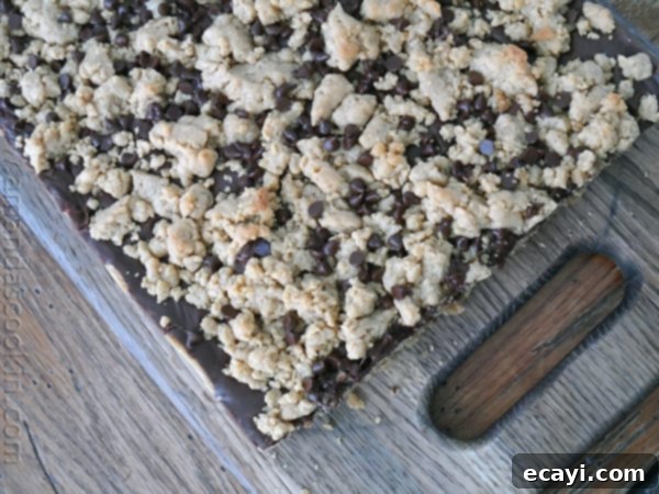 Peanut Butter Chocolate Bliss Bars 6 An overhead photo of peanut butter chocolate layer bars fresh out of the pan resting on a wooden cutting board.