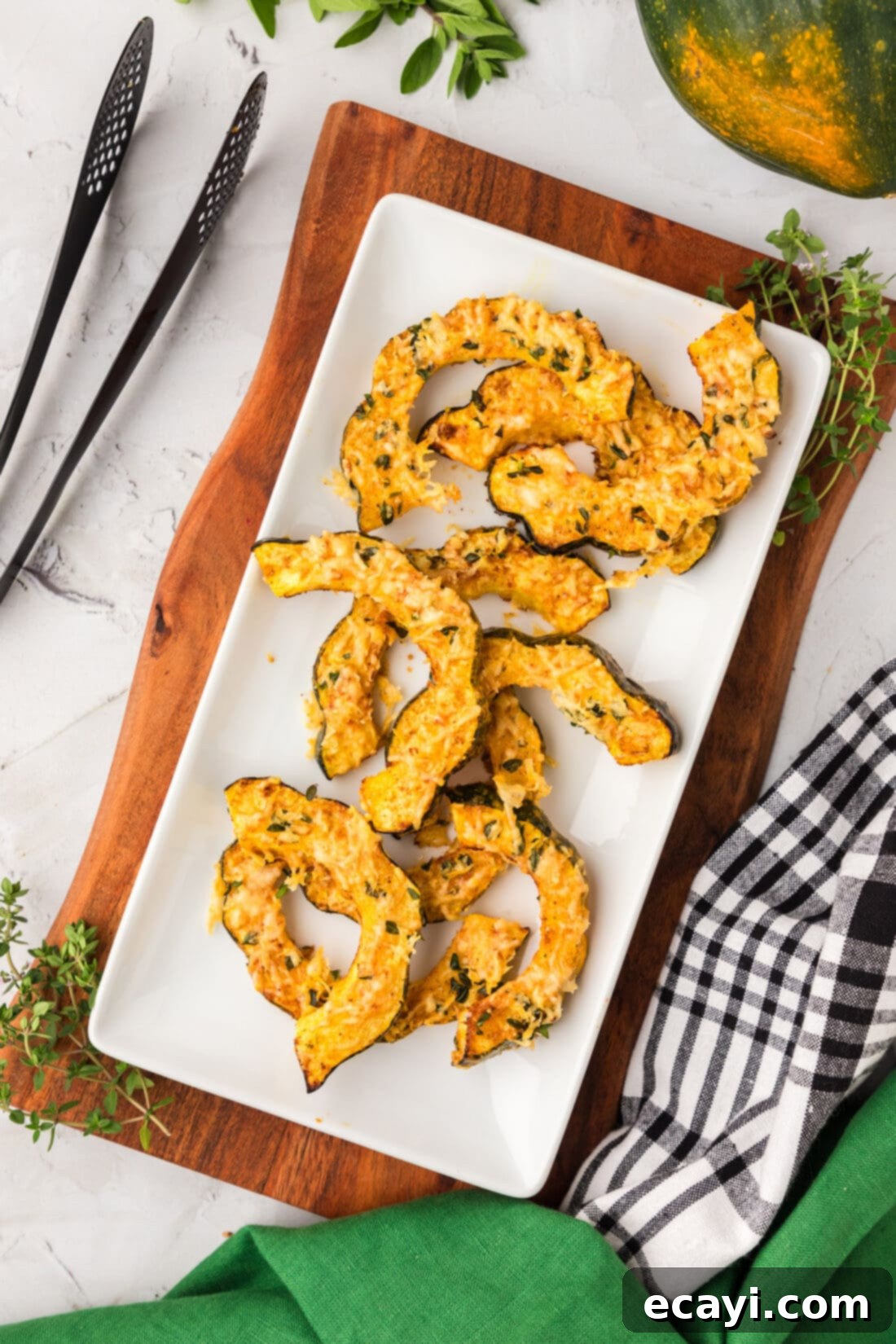 Delicious Air Fryer Acorn Squash 2 Air Fryer Acorn Squash on a platter, golden brown with herbs and cheese