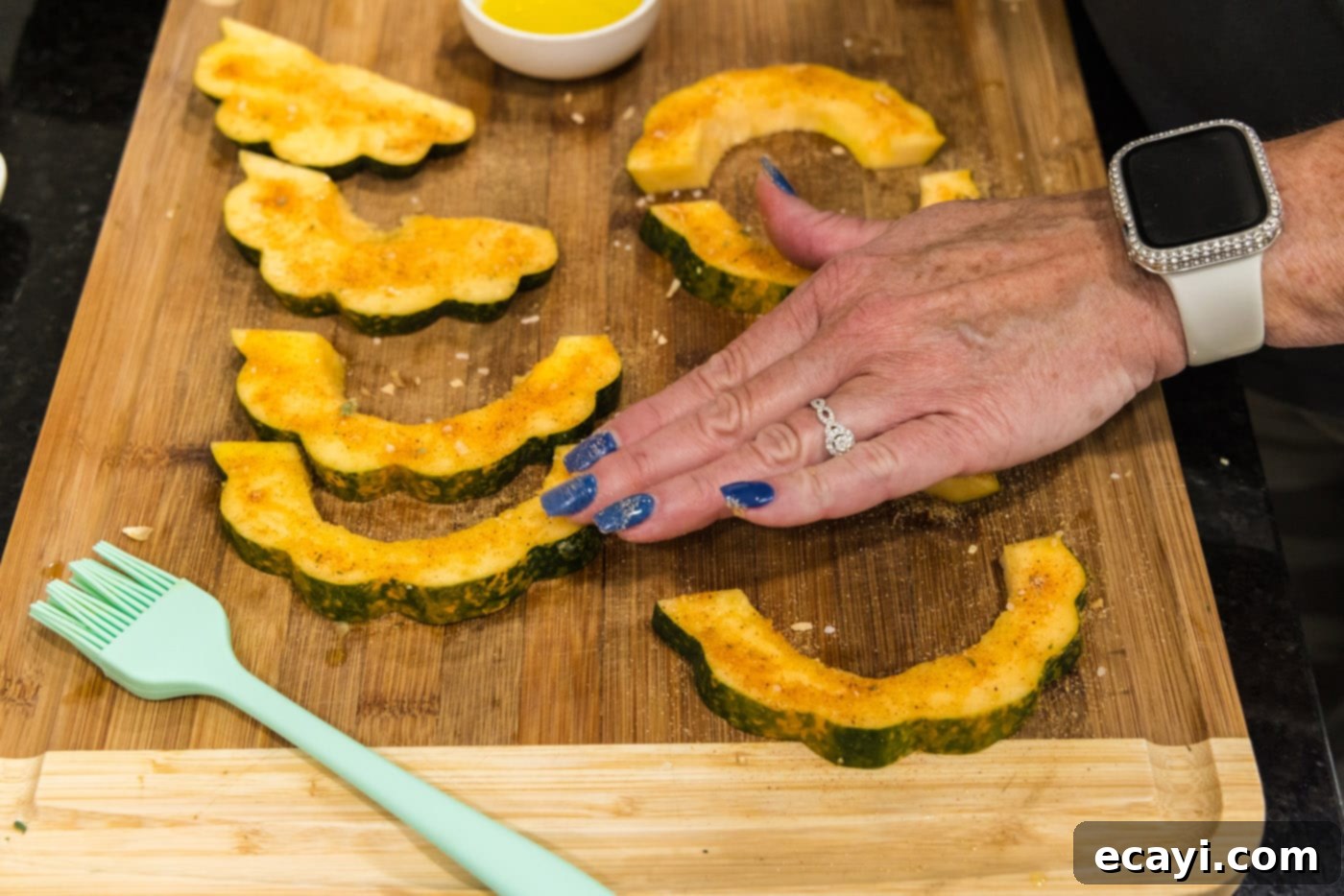 Delicious Air Fryer Acorn Squash 12 rubbing all purpose seasoning on acorn squash slices