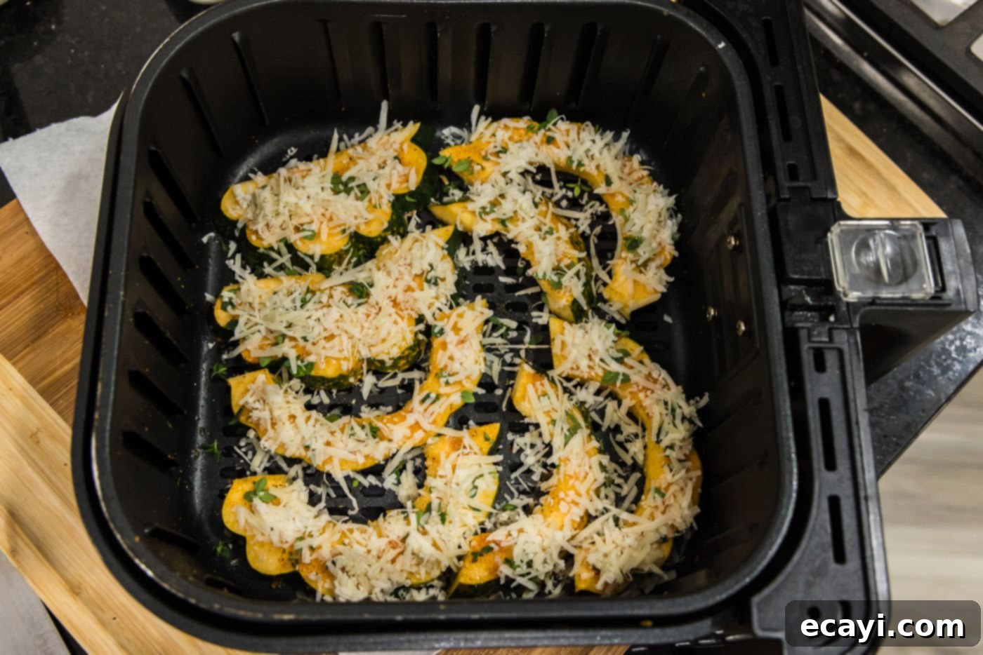 Delicious Air Fryer Acorn Squash 15 shredded parmesan cheese added to sliced acorn squash in an air fryer