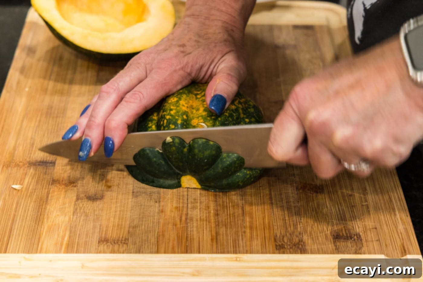 Delicious Air Fryer Acorn Squash 8 slicing an acorn squash on a cutting board