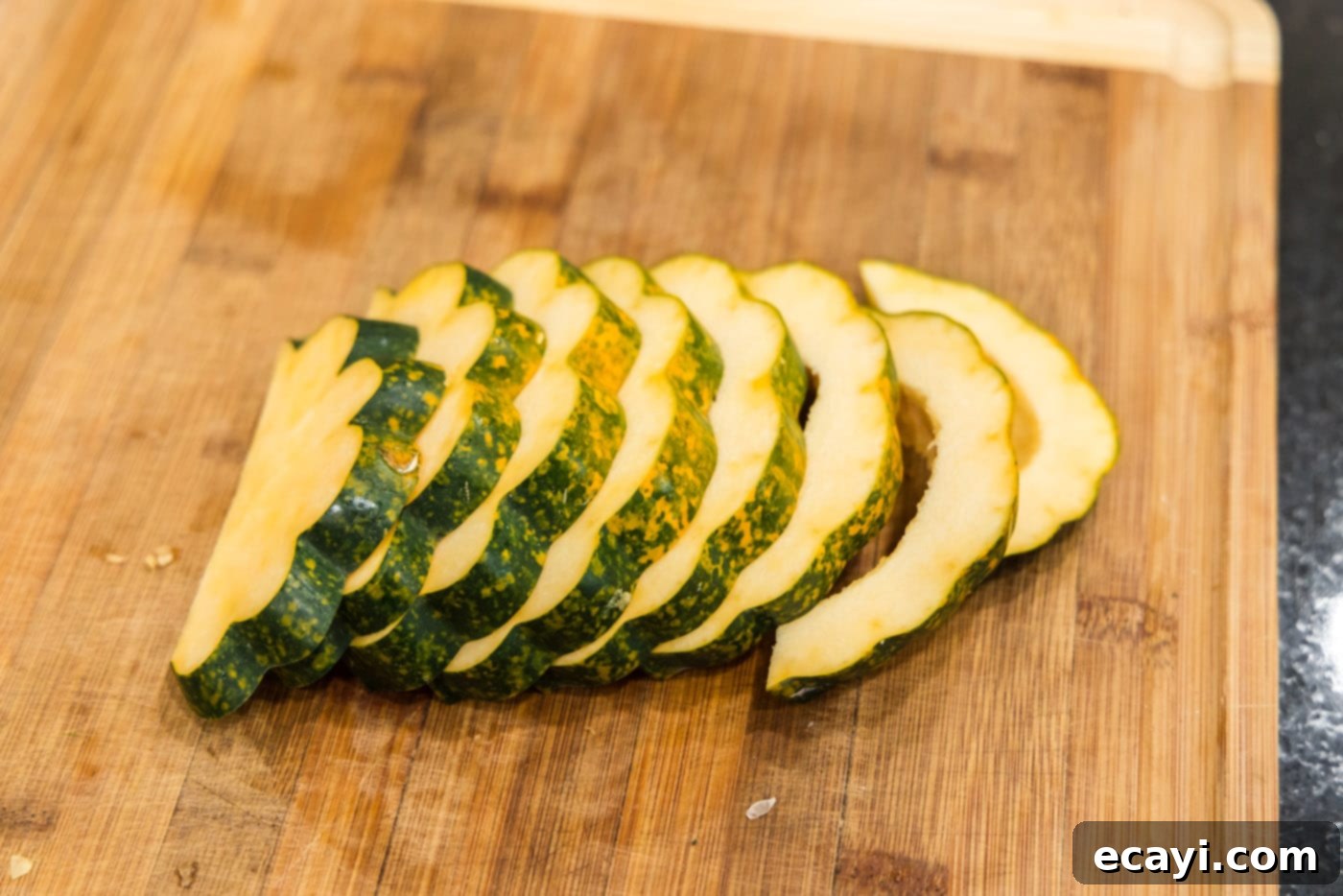 Delicious Air Fryer Acorn Squash 10 sliced acorn squash on a cutting board