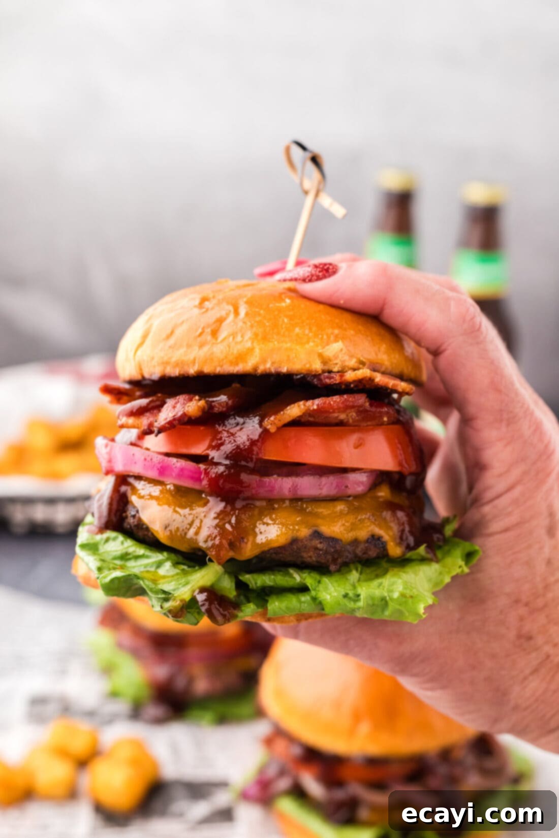 Smoky BBQ Bacon Burgers 3 Hand holding up a BBQ Bacon Burger