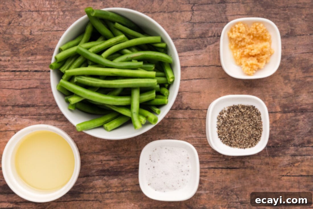 Crispy Air Fryer Green Beans 4 A selection of fresh ingredients laid out, including green beans, minced garlic, olive oil, salt, and pepper.