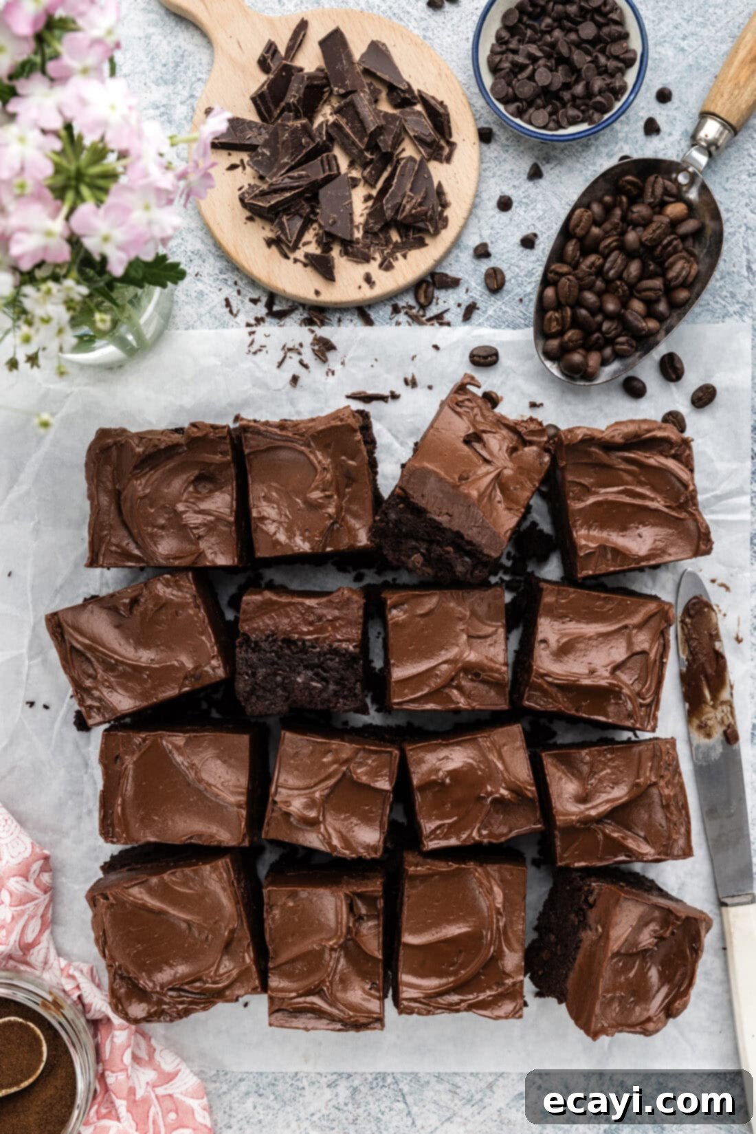 Decadent Espresso Fudge Brownies 2 Fudge Frosted Espresso Brownies cut into squares on parchment paper, highlighting their thick, chewy texture and rich frosting