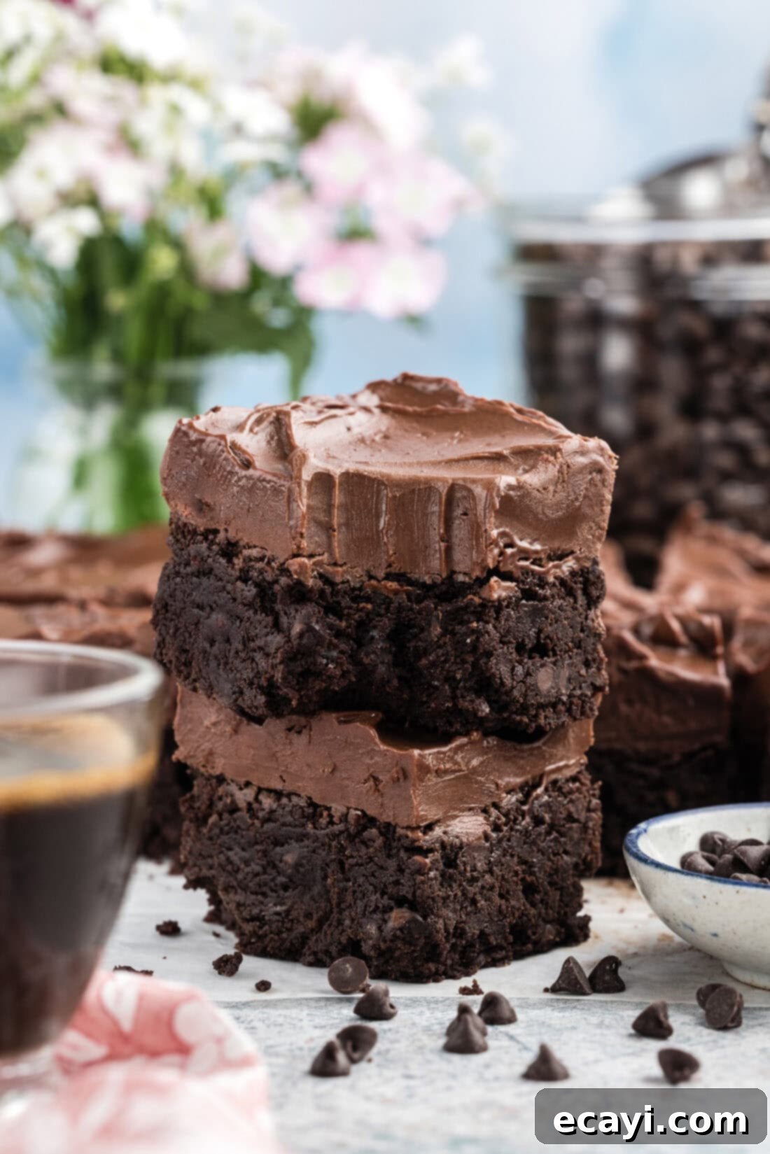 Decadent Espresso Fudge Brownies 3 Stack of Fudge Frosted Espresso Brownies with a bite taken out of the top one, showcasing the rich, dense texture and creamy frosting