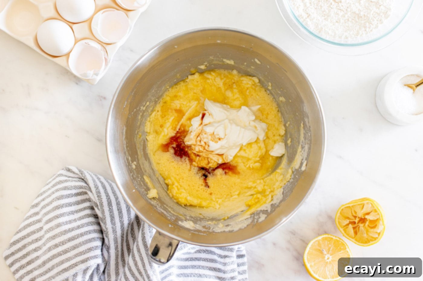 Zesty Lemon Loaf 8 adding sour cream and vanilla to butter mixture in a bowl