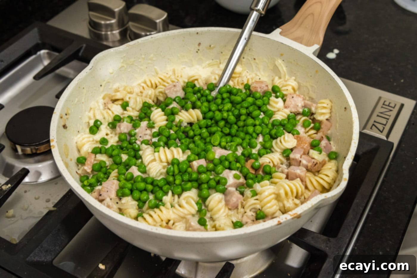 Smoked Turkey Carbonara 15 Frozen peas being added to the turkey carbonara mixture in the skillet