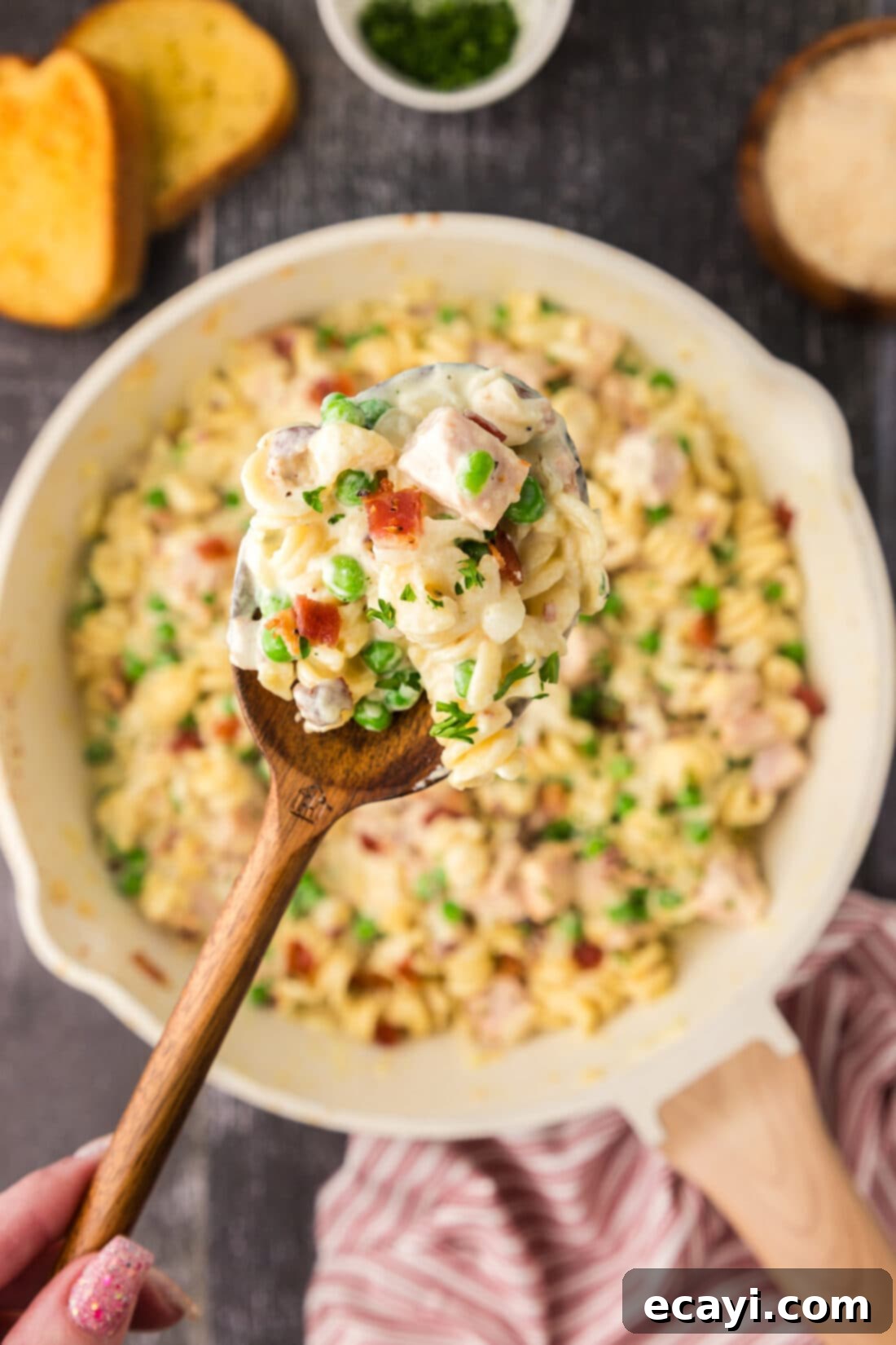 Smoked Turkey Carbonara 17 Spoonful of creamy Turkey Carbonara held up above a skillet filled with the dish