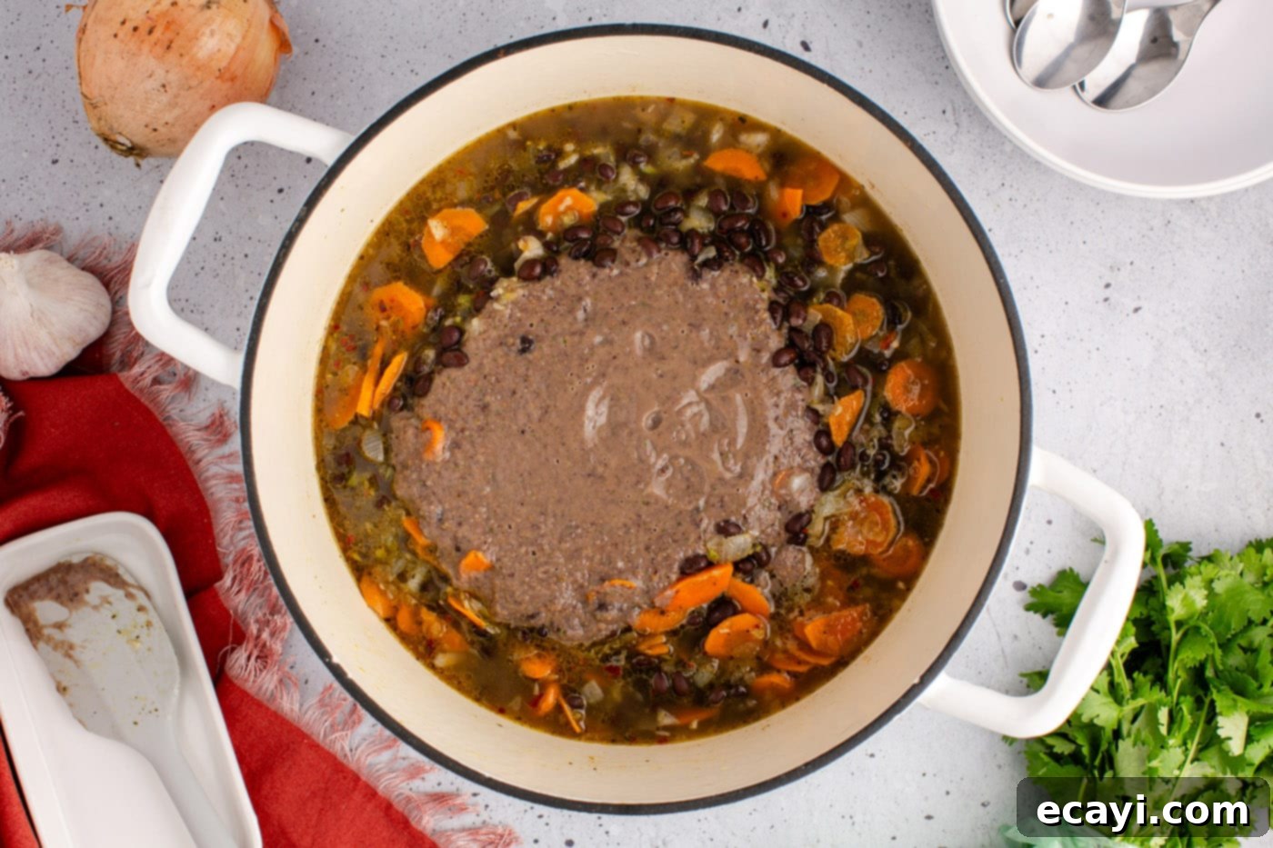 Savory Black Bean Delight 12 Adding the creamy, blended black bean soup back into the main pot of unblended soup, to combine for a rich and varied texture.