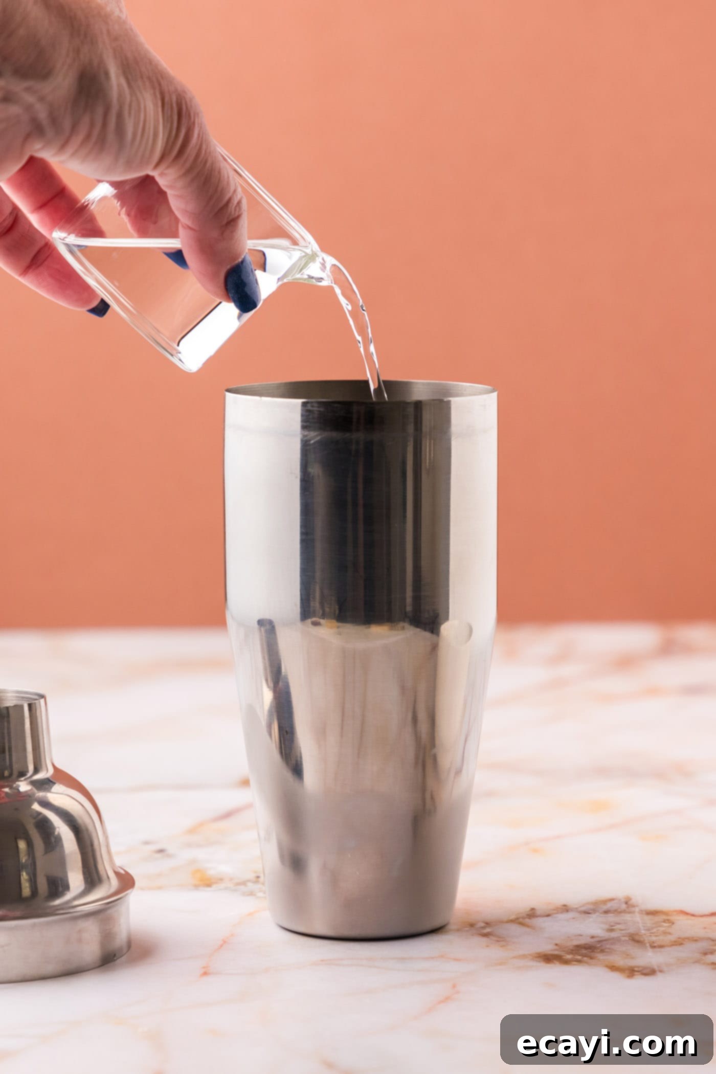 The Parisian Raspberry Sip 5 pouring vodka into cocktail shaker