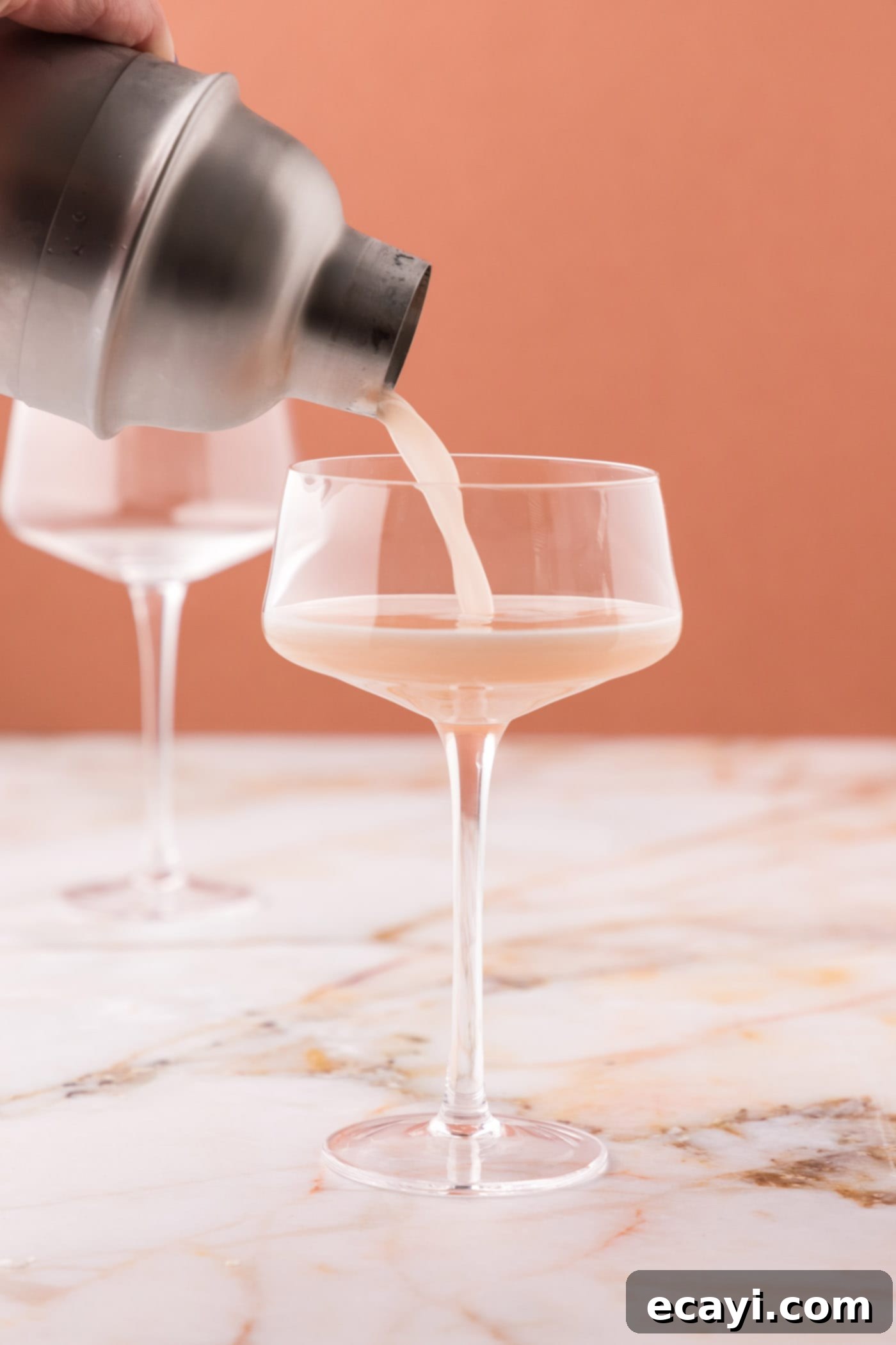 The Parisian Raspberry Sip 9 straining french martini into a glass