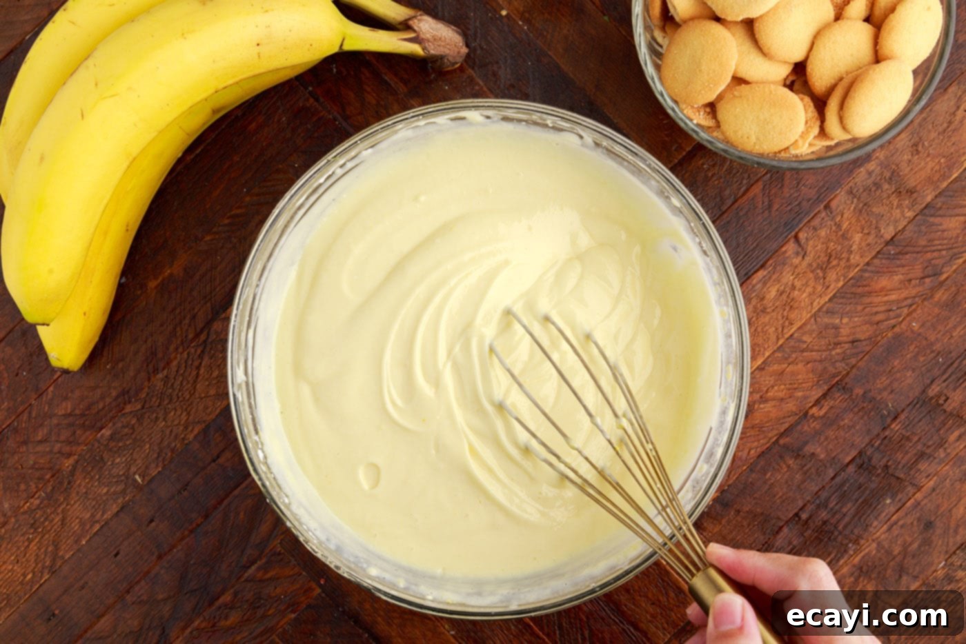 Decadent Banana Layers 7 whisking whipped vanilla pudding and cream cheese mixture in a bowl
