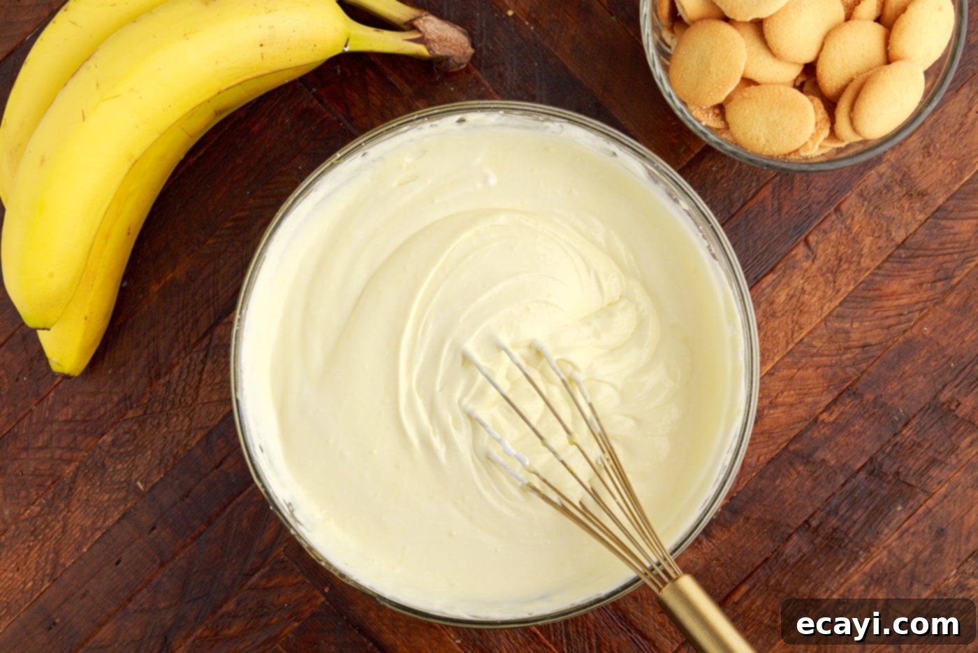 Decadent Banana Layers 9 whipped cream cheese vanilla pudding mixture in a bowl with a whisk