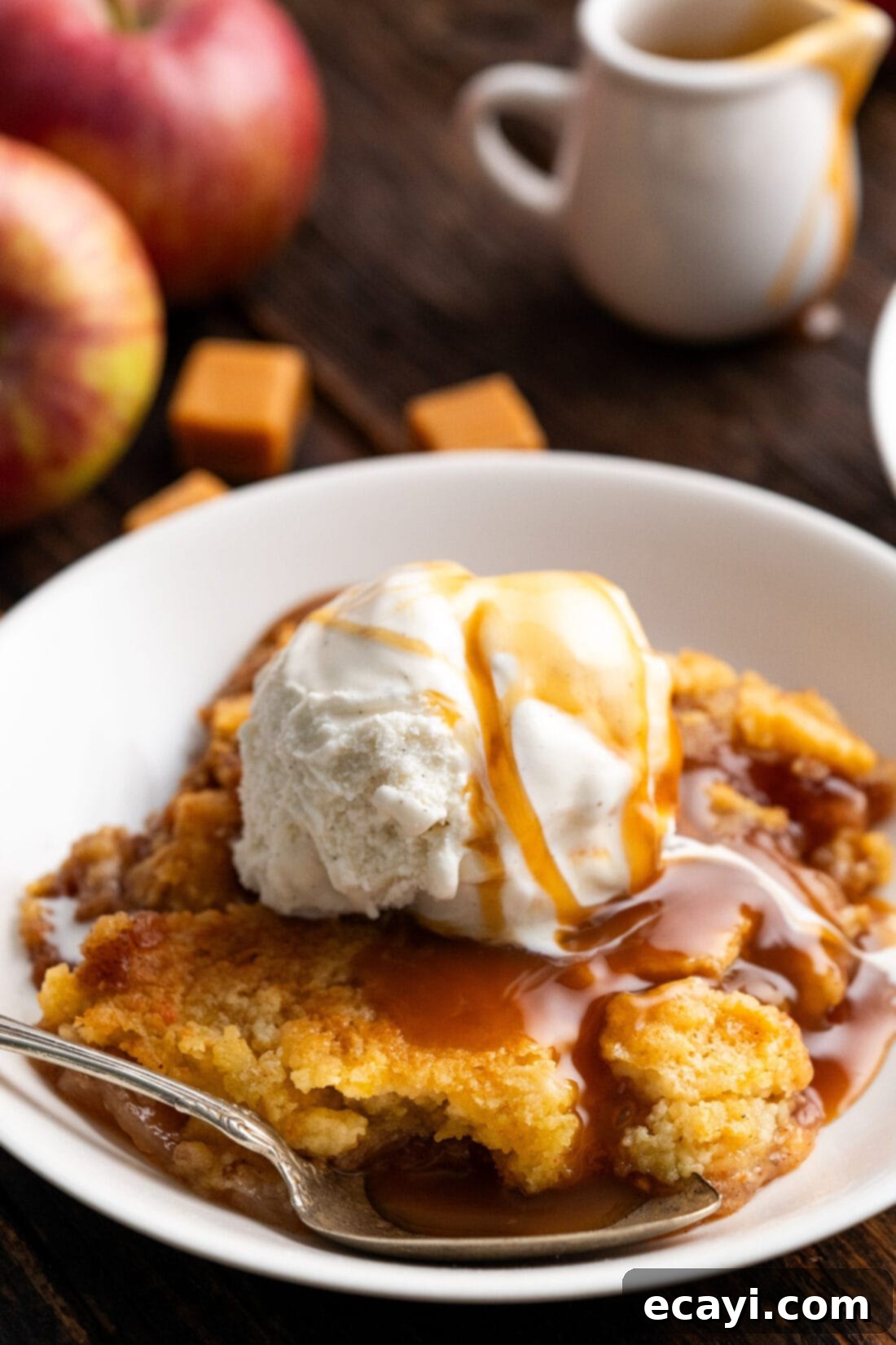 Gooey Caramel Apple Delight 13 Caramel Apple Dump Cake in a bowl topped with ice cream and caramel sauce