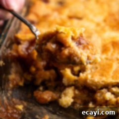 Gooey Caramel Apple Delight 14 Close up photo of a spoonful of Caramel Apple Dump Cake being lifted out of the pan