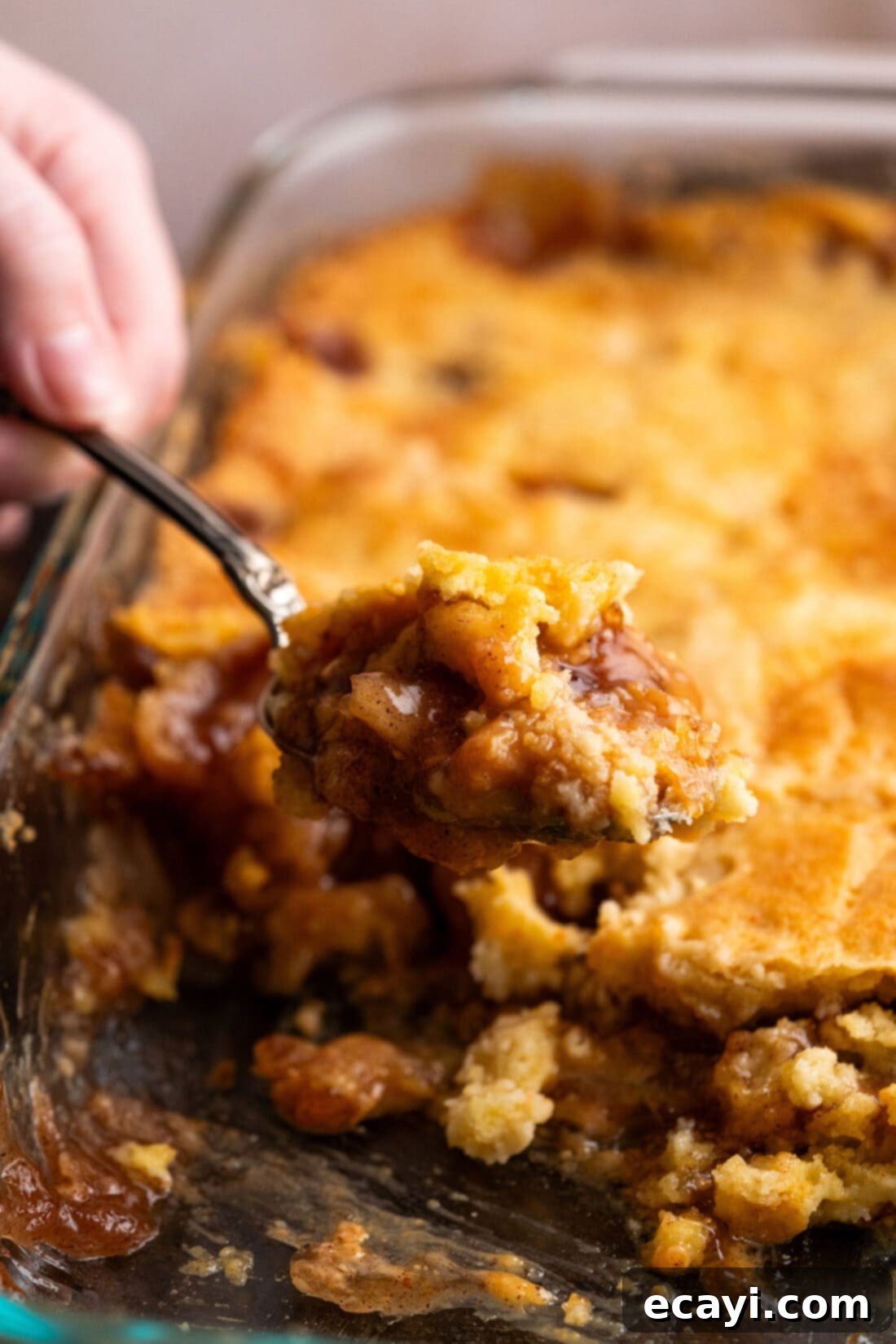 Gooey Caramel Apple Delight 3 Scoop of Caramel Apple Dump Cake being lifted out of the pan