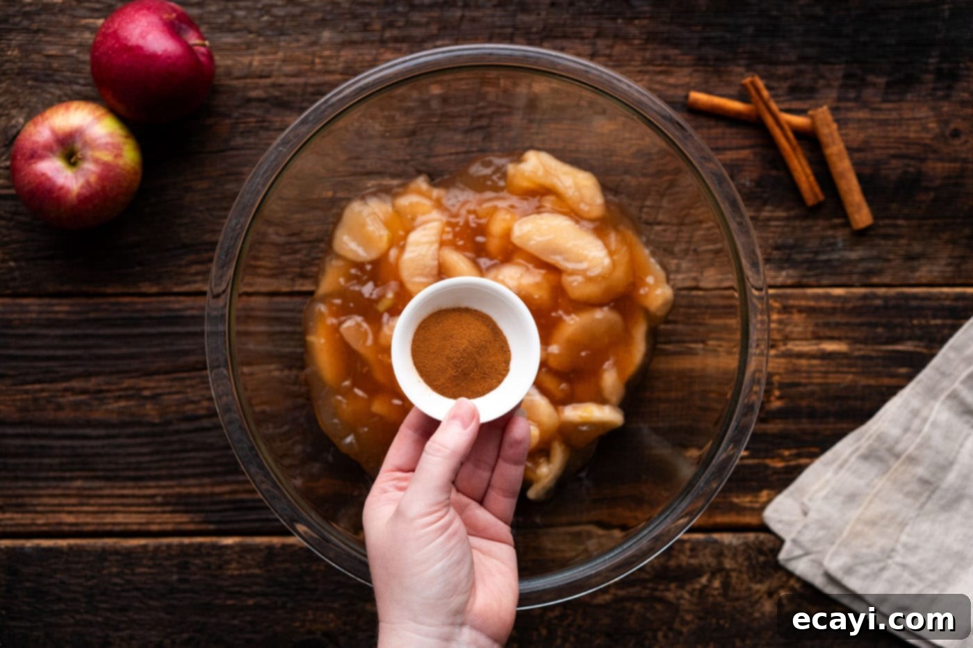 Gooey Caramel Apple Delight 5 adding cinnamon to apple pie filling