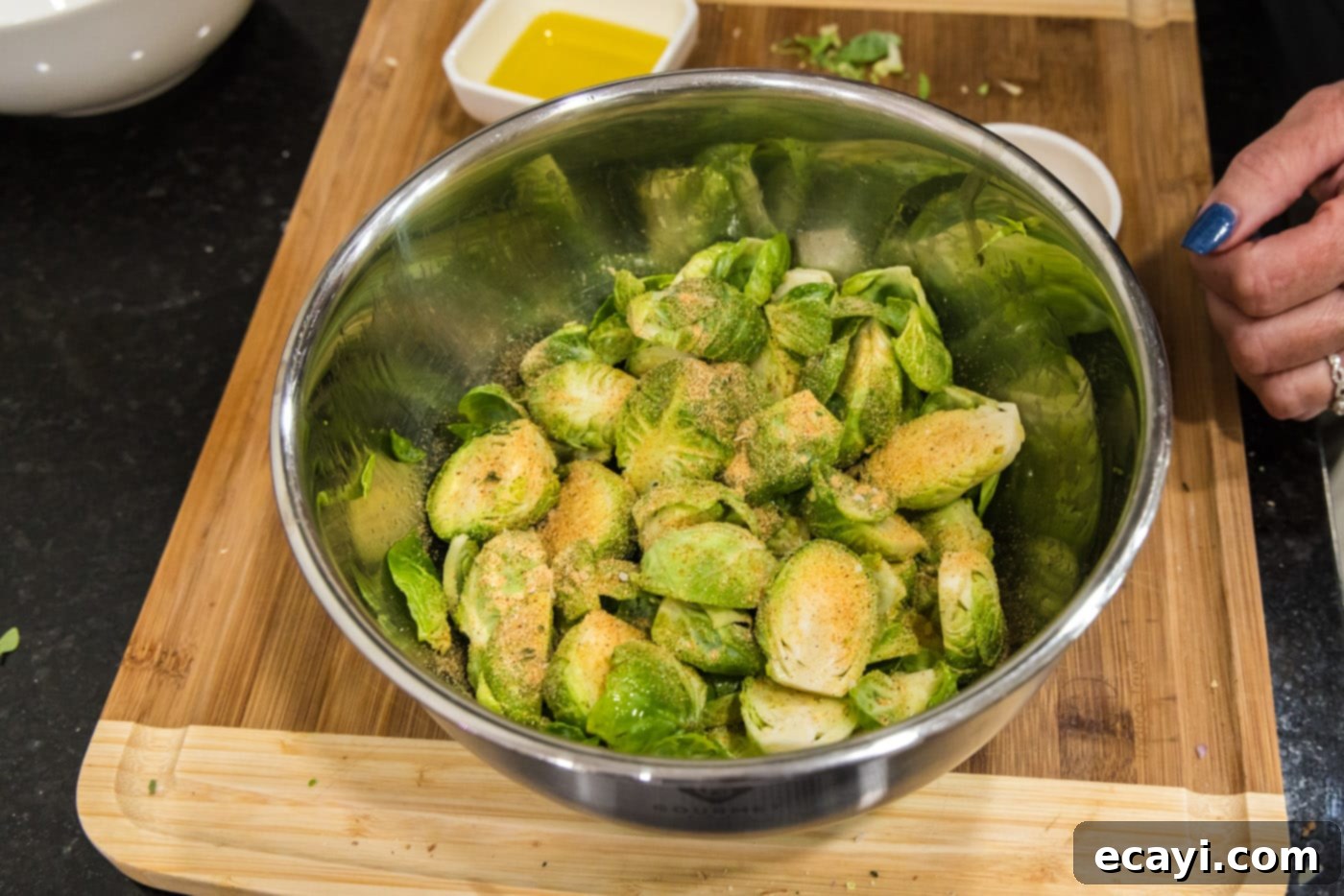 Roasted Brussels Sprouts with Crispy Bacon and Glazed Pecans 7 Brussels sprouts in a bowl with seasoning, ready to be tossed.