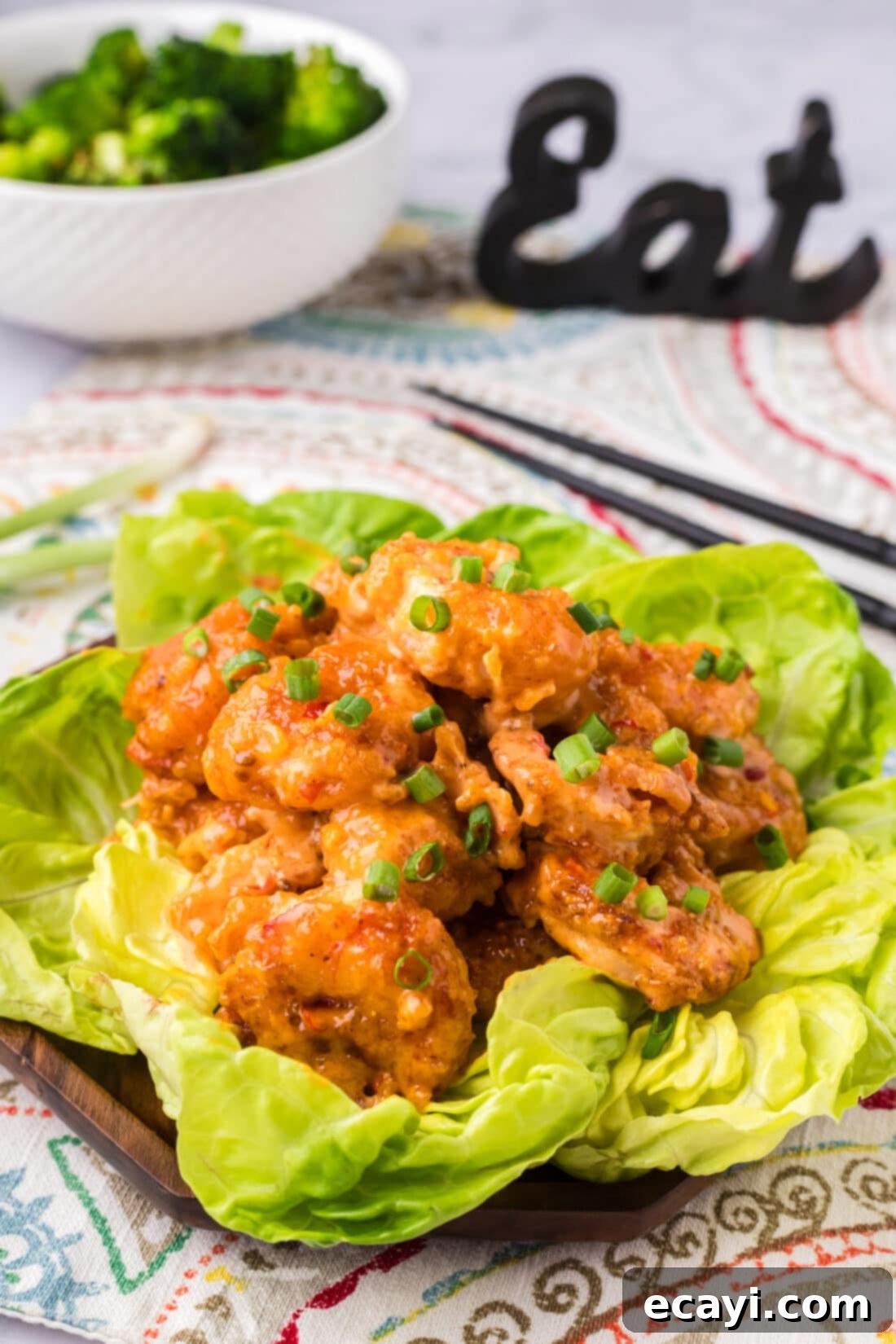 Bang Bang Shrimp 2 Bang Bang Shrimp on a bed of lettuce with a bowl of broccoli in the background