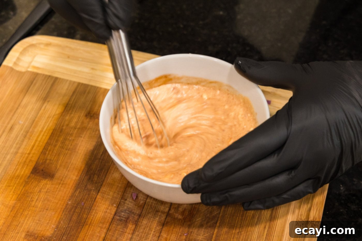Bang Bang Shrimp 5 whisking bang bang sauce in a bowl