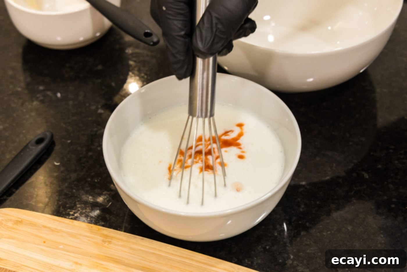 Bang Bang Shrimp 6 whisking hot sauce and buttermilk in a bowl