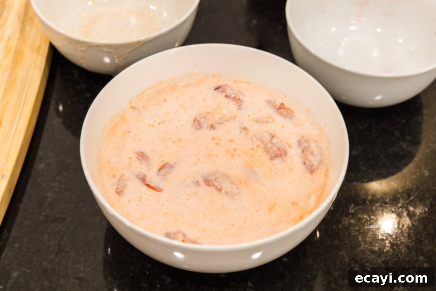 Bang Bang Shrimp 8 shrimp marinating in buttermilk and hot sauce