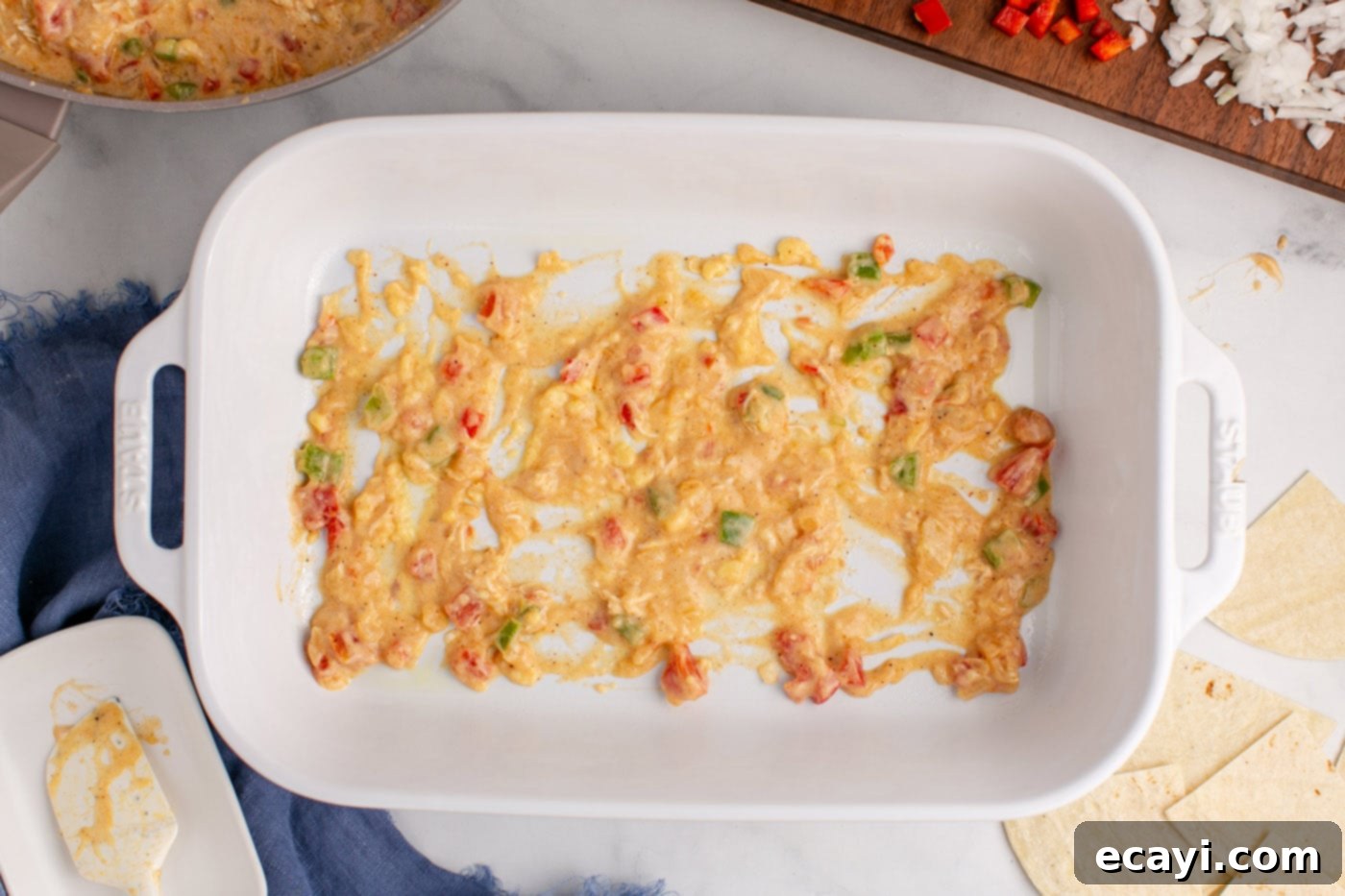Comforting King Ranch Chicken Casserole 11 A thin layer of sauce mixture spread across the bottom of a baking dish.