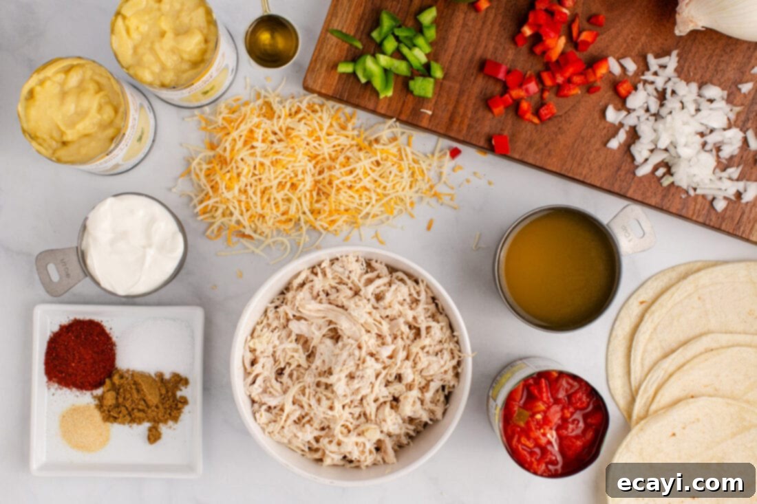 Comforting King Ranch Chicken Casserole 4 A collection of ingredients laid out on a counter, including shredded chicken, bell peppers, onions, cans of soup, cheese, and spices, ready for King Ranch Chicken Casserole.