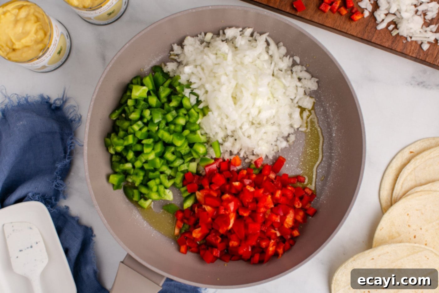 Comforting King Ranch Chicken Casserole 5 Diced bell peppers and onion cooking in a skillet with oil.