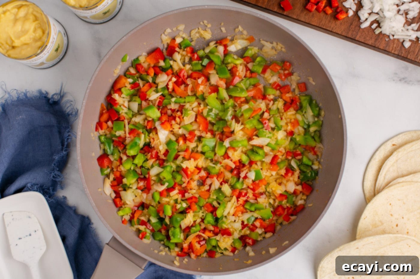 Comforting King Ranch Chicken Casserole 6 Sautéed bell peppers and onion in a skillet, softened and ready for the next step.
