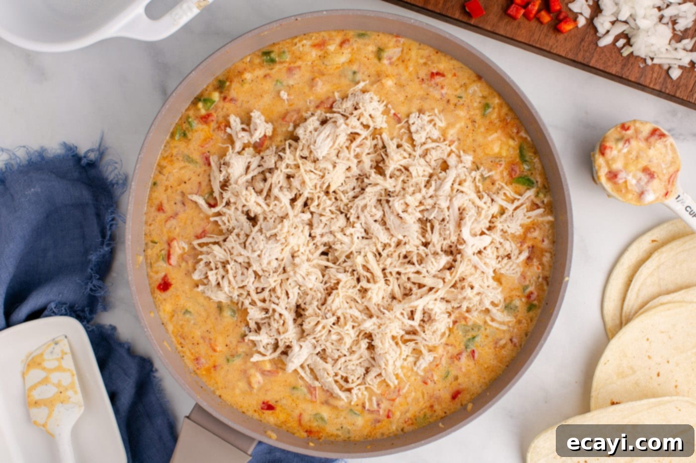 Comforting King Ranch Chicken Casserole 9 Shredded chicken being stirred into the creamy sauce for the King Ranch Casserole.